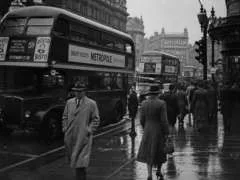 An archival street photo at 240 by 180 pixels, with unreadable signs